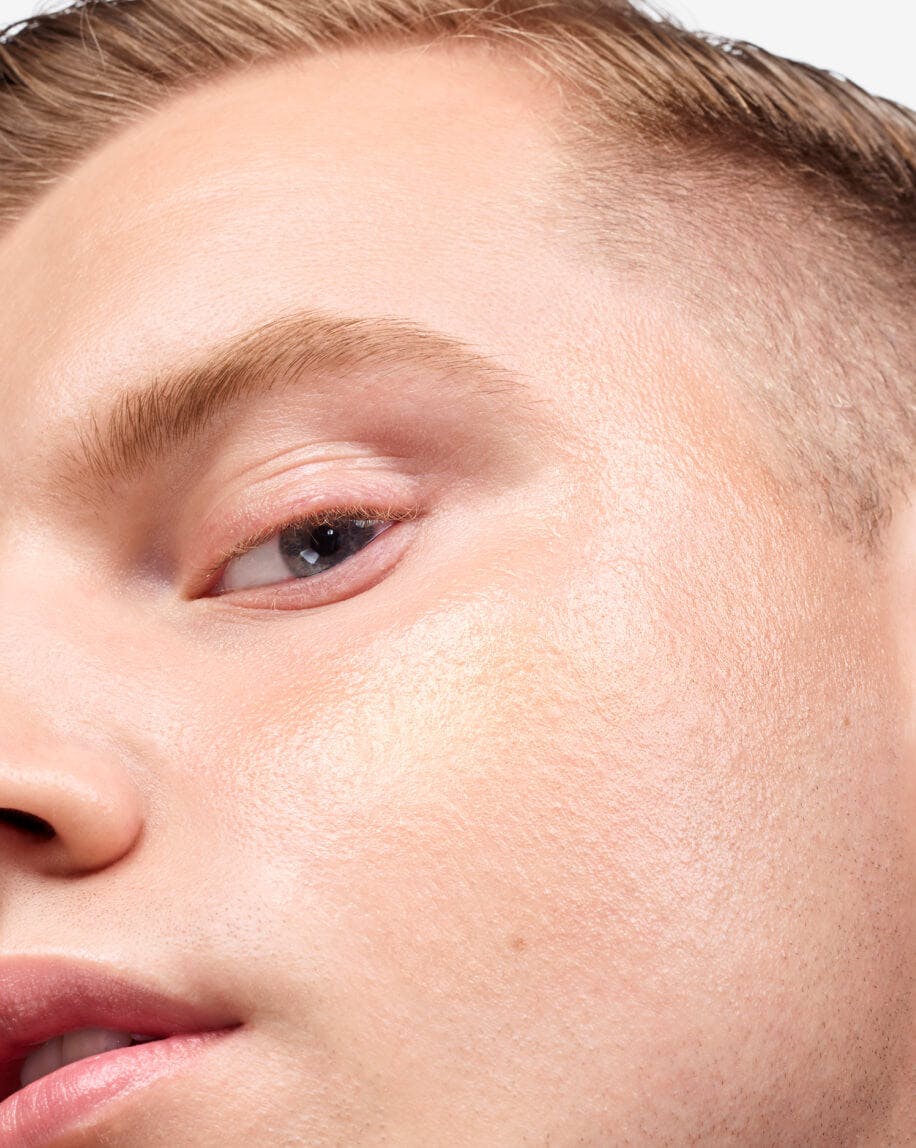 close up of model's cheek wearing haloscope in topaz